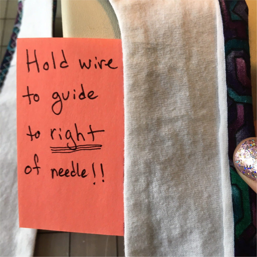 Hold wire to guide to right of needle!